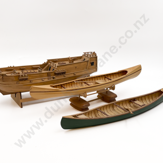 Two Wooden Canoes Together with Model Ship
