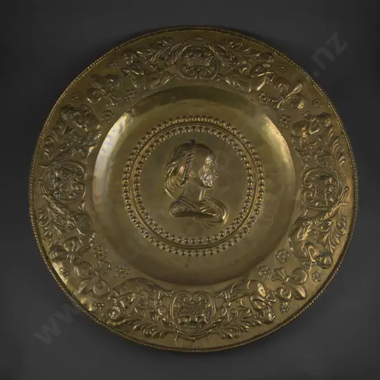 A Large Embossed Brass Circular Wall Plaque