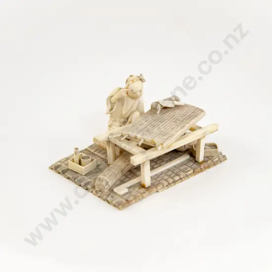 A Japanese Ivory Artisan Surrounded By Work Items