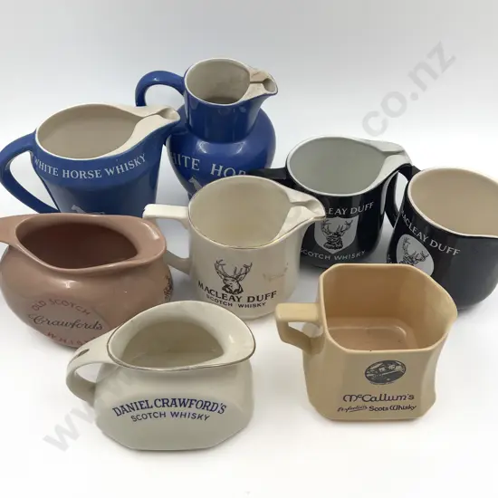 Eight Assorted Whisky Advertising Jugs