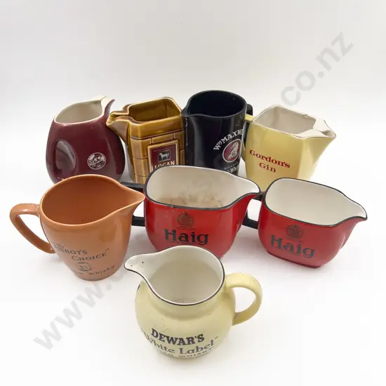 Eight Assorted Whisky Advertising Jugs