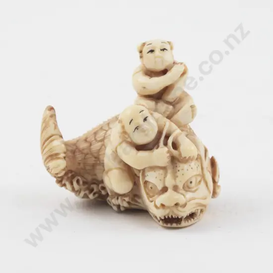 Signed Ivory Netsuke of Two Children Riding a Demon Fish