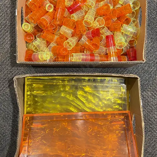 Two Boxes of Assorted Decorative Plastic Shot Glasses and Chopping Boards